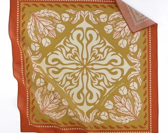 May include: Square bandana with a floral design in shades of orange, cream, and olive green. The border is a solid orange with a dotted pattern. The center features a symmetrical floral pattern.