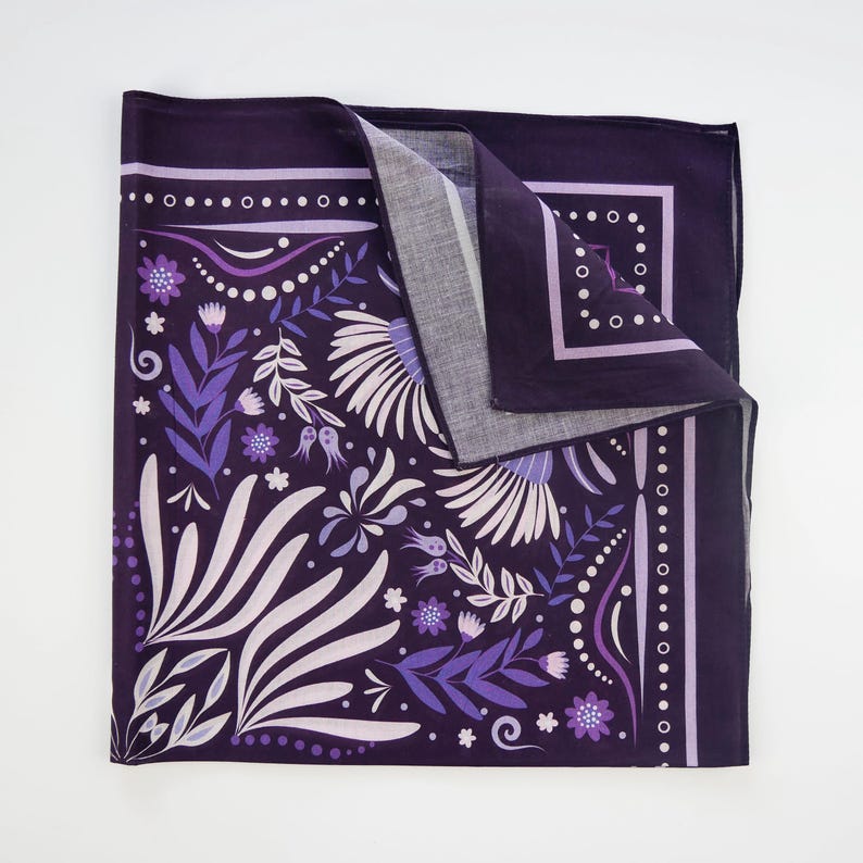 May include: Purple bandana with a floral pattern in shades of purple and white. The bandana has a white border with a repeating pattern of small circles.