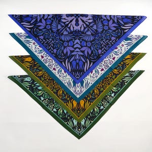 May include: Four triangular bandanas with different floral patterns. The top bandana is blue with a purple and white floral design. The second bandana is white with a purple and green floral design. The third bandana is green with a yellow and orange floral design. The bottom bandana is teal with a green and white floral design.