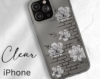 May include: Clear phone case with a brick pattern and black and white floral design. The case is compatible with iPhone 16, 15, 14, and 13 models, including Pro, Max, Plus, and Mini.