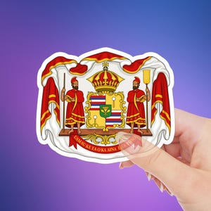 May include: A sticker featuring the Hawaiian coat of arms. The design includes a crown, two figures in red robes, and a shield with the Hawaiian flag and other symbols. The text "Ua Mau Ke Ea O Ka Aina I Ka Pono" is on a banner.