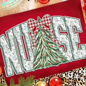 Op de afbeelding: Rode achtergrond met het woord "NURSE" in witte letters met een groen bloemmotief. Een kerstboom met rode ornamenten en een rood-wit geblokte strik staat in het midden. Feestelijke vakantiedecoratie.