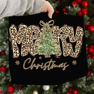 May include: Black Christmas-themed design featuring the words "MERRY Christmas" in a gold leopard print font. A green Christmas tree with lights is in the center. Gold snowflakes are on either side.