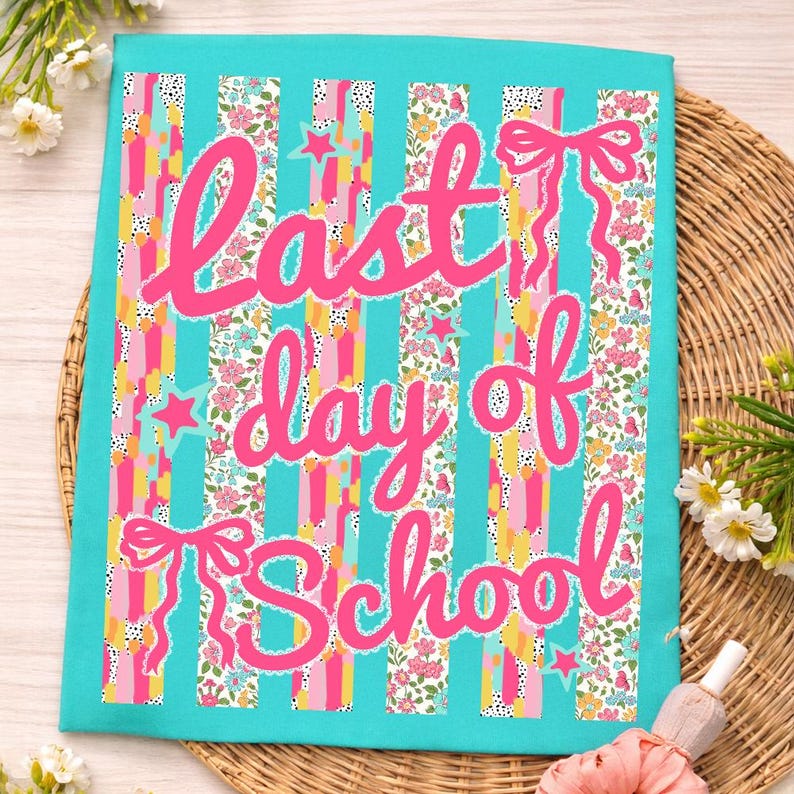 Puede incluir: Una tela turquesa con las palabras "last day of school" en rosa. El fondo presenta rayas verticales con varios patrones, incluyendo flores y lunares, con lazos y estrellas rosas.