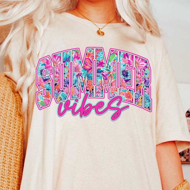 K&ouml;nnte beinhalten: Ein wei&szlig;es T-Shirt mit einer pinkfarbenen Blumengrafik, auf der "Summer Vibes" steht.