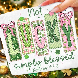 Puede incluir: Un objeto decorativo rectangular blanco con las palabras "Not LUCKY simply blessed" en verde y rosa. La palabra LUCKY está en bloques individuales con diseños de tréboles y lazos. También está presente el texto "Romans 4:7-8".