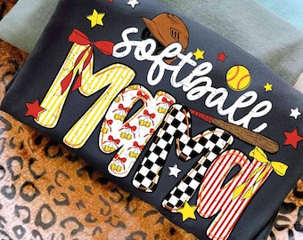 Puede incluir: Camiseta gris oscuro con las palabras "Softball Mom" en una fuente decorativa colorida. El diseño incluye un casco de béisbol, una pelota y un bate. Las letras son amarillas, rojas, blancas y negras.