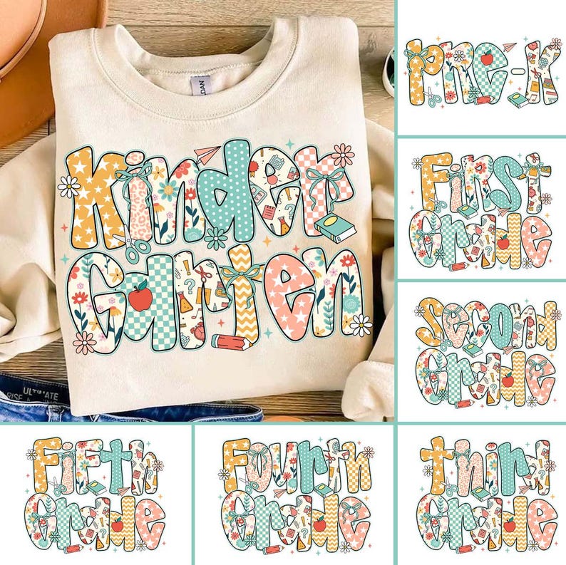 May include: Cream-colored sweatshirt with the word "Kindergarten" in a colorful, patterned design. Additional graphics include flowers, pencils, and books. Other designs show "Pre-K" through "Fifth Grade" in similar styles.