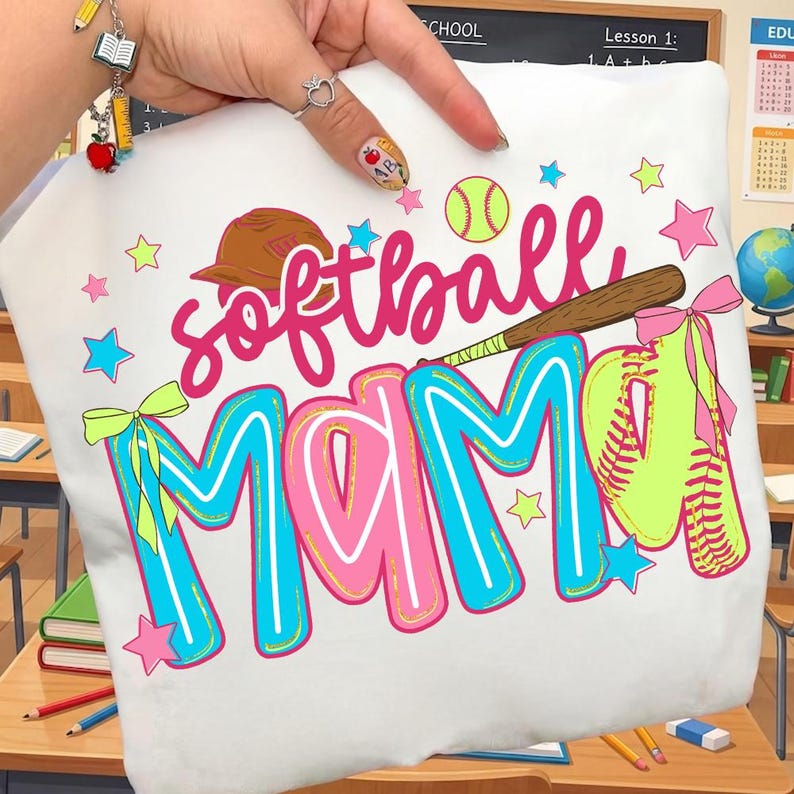 May include: White t-shirt with the words "softball MAMA" in pink and blue, along with a baseball, glove, and stars. The design includes a brown baseball bat and a brown baseball cap.