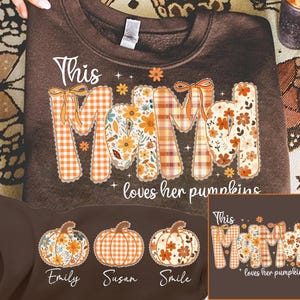 May include: A brown sweatshirt featuring the text "This Mom loves her pumpkins". The word "MOM" is decorated with floral and plaid patterns. The image also shows three pumpkin designs with names at the bottom.