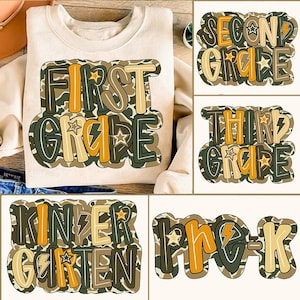 Könnte beinhalten: Ein cremefarbenes Sweatshirt mit einer großen, farbenfrohen Grafik mit der Aufschrift "FIRST GRADE" in einer Schriftart im Camouflage-Stil. Zusätzliche Grafiken zeigen "SECOND GRADE", "THIRD GRADE", "KINDERGARTEN" und "Pre-K" in ähnlichen Stilen. Das Design enthält Sterne und Blitze.