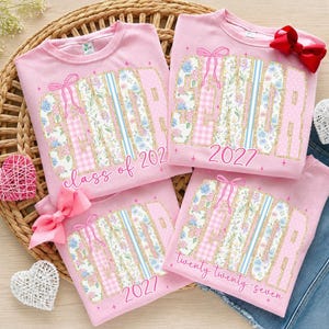 May include: Four light pink t-shirts featuring the word SENIOR in large block letters filled with floral, gingham, and striped patterns. The designs include pink bows, stars, and the text class of 2027 or twenty twenty-seven in cursive script.