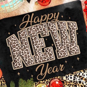 K&ouml;nnte beinhalten: Schwarze rechteckige Matte mit den Worten "Happy NEW Year" in einem Leopardenmuster. Die Matte ist mit goldenen Sternen, Weihnachtskugeln und einer Discokugel verziert.
