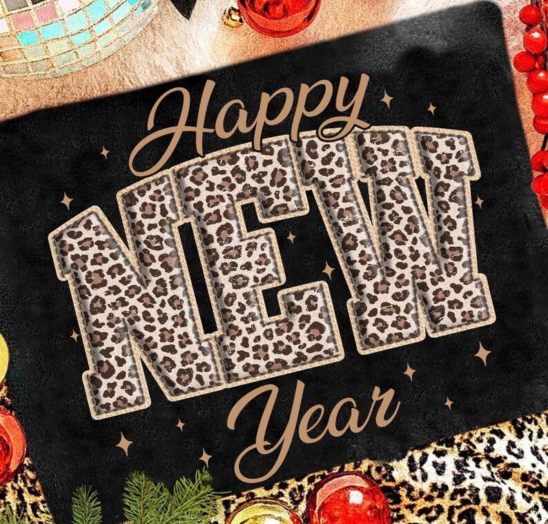 K&ouml;nnte beinhalten: Schwarze rechteckige Matte mit den Worten "Happy NEW Year" in einem Leopardenmuster. Die Matte ist mit goldenen Sternen, Weihnachtskugeln und einer Discokugel verziert.