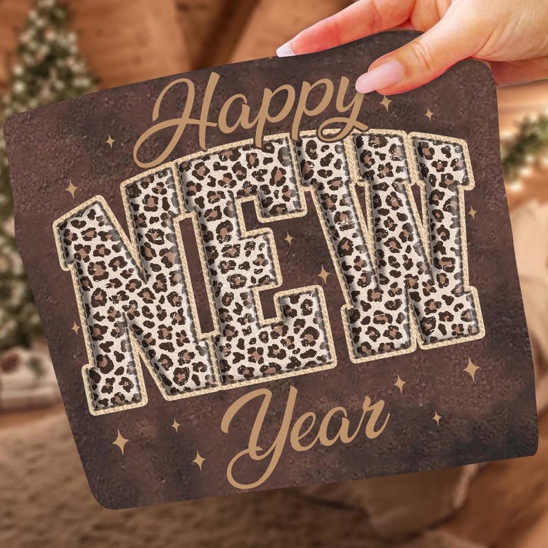 K&ouml;nnte beinhalten: Ein quadratischer Untersetzer mit braunem Hintergrund und den Worten "Happy New Year" in einer dekorativen Schriftart. Die Buchstaben "NEW" sind mit einem Leopardenmuster gef&uuml;llt, und kleine goldene Sterne sind um den Text herum verstreut.