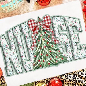 Op de afbeelding: Een kerstthema-ontwerp met het woord "NURSE" in een lettertype in varsity-stijl. De letters zijn versierd met een bloemenpatroon en omrand met groene stiksels. Een kerstboom met een rode strik staat in het midden.
