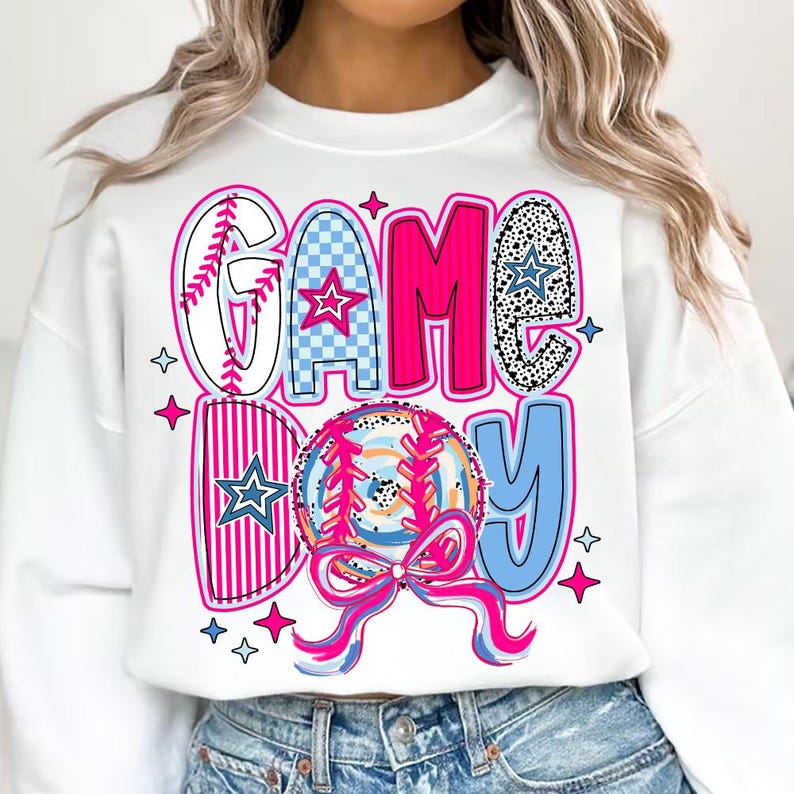 May include: White sweatshirt with a pink, blue, and white graphic design that says "GAME DAY" with a baseball and stars.