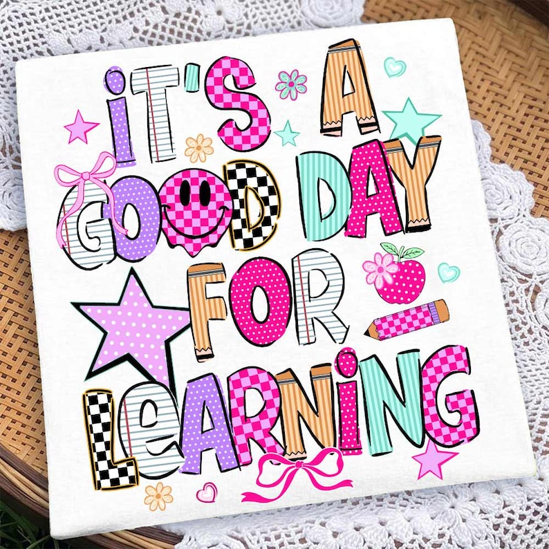 May include: A white square fabric panel featuring the colorful text IT'S A GOOD DAY FOR LEARNING. The letters are decorated with various patterns including checkers, stripes, and polka dots in pink, purple, teal, and tan, with a smiley face and pencil.