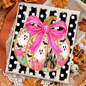May include: A rectangular canvas print featuring a large pumpkin decorated with a bright pink bow, white ghosts, small bats, gold stars, and a black castle. The background consists of vertical black stripes with white polka dots.