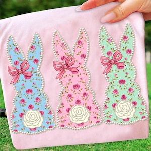 Könnte beinhalten: Ein Set aus drei Keramikbechern mit gesprenkelter, matter Oberfläche. Die Becher sind in den Farbtönen Creme, Hellgrau und Dunkelgrau gehalten. Jeder Becher hat ein schlichtes, minimalistisches Design und einen abgerundeten Henkel.