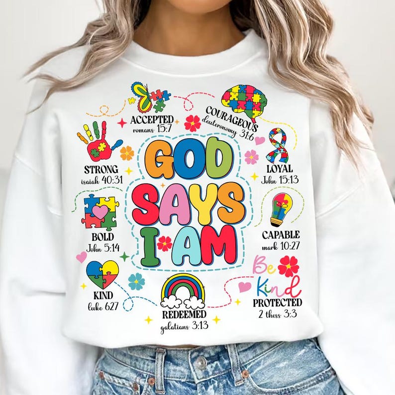 May include: White sweatshirt with a colorful graphic design that says "God Says I Am" with bible verses and words like "strong", "bold", "kind", "courageous", "loyal", "capable", "accepted", "redeemed", and "protected".