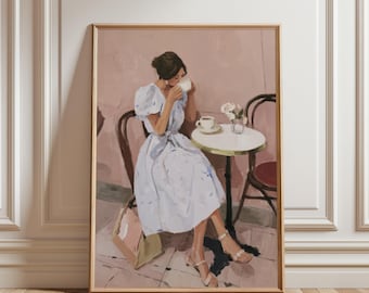 May include: A framed art print depicting a woman in a light blue dress, seated at a cafe table, drinking from a white teacup. The scene includes a small table, chairs, and a vase of flowers, rendered in a soft, painterly style.