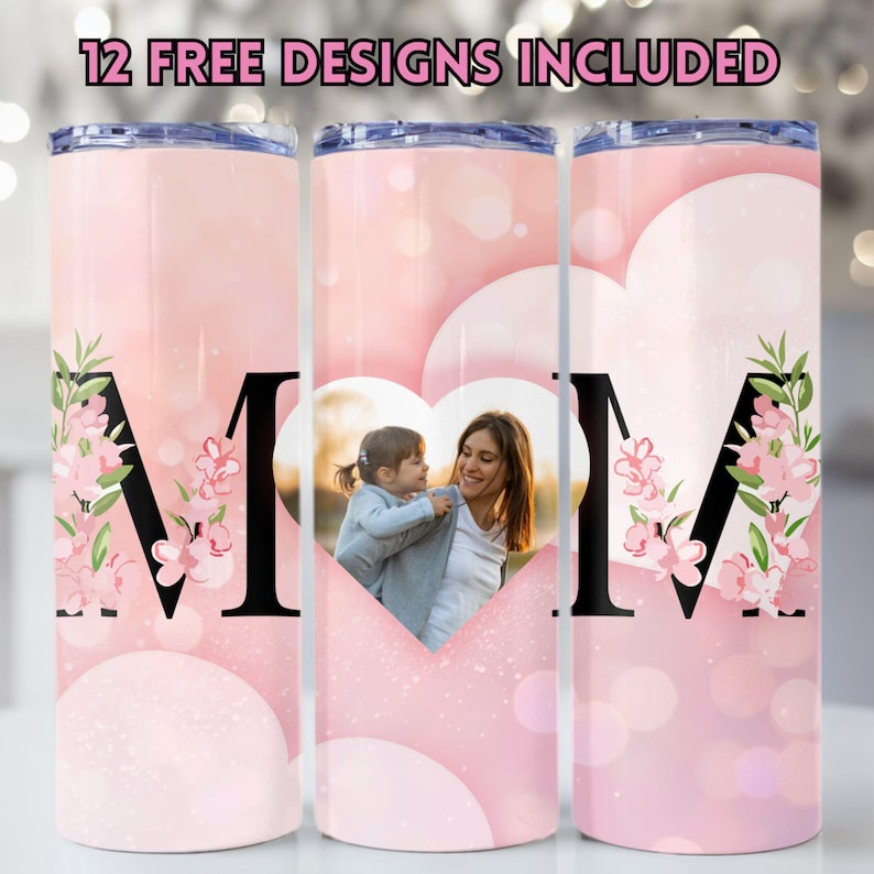 May include: Three pink stainless steel tumblers with a heart-shaped photo frame and the letter "M" decorated with pink flowers. The text "12 FREE DESIGNS INCLUDED" is at the top of the image.