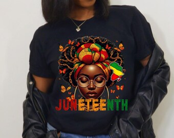 May include: Black t-shirt with a graphic of a woman with a colorful head wrap and the word "Juneteenth" in red, yellow, and green.