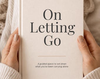 May include: A cream-coloured hardback book titled On Letting Go with dark grey serif lettering. The cover features a horizontal line and the subtitle A guided space to set down what you've been carrying alone printed in a smaller, simple font.