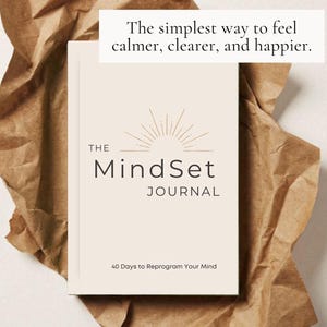 May include: A cream-coloured journal titled "The Mindset Journal" with the text "40 Days to Reprogram Your Mind." The journal is on brown paper with the text "The simplest way to feel calmer, clearer, and happier."