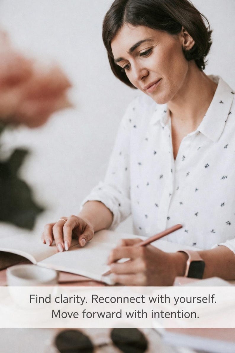 May include: A woman writing in a notebook with a pencil. She wears a white button-down shirt with a small black pattern and a rose gold watch. The text on the image reads: Find clarity. Reconnect with yourself. Move forward with intention.