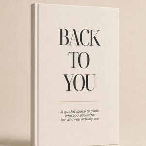 May include: A hardback book with a cream-coloured cover featuring the black text BACK TO YOU in a large serif font. Below this, a thin horizontal line separates the title from the subtitle: A guided space to trade who you should be for who you actually are.