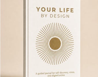 Może przedstawiać: Biały dziennik w twardej oprawie z tytułem YOUR LIFE BY DESIGN w złotym kolorze. Okładka zawiera złotą grafikę słońca oraz tekst A guided journal for self-discovery, vision, and aligned action wydrukowany mniejszą złotą czcionką.