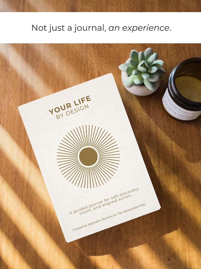 May include: A journal titled "YOUR LIFE BY DESIGN" with a sunburst design on the cover. The journal is accompanied by a small succulent in a white pot and a jar. The text reads "Not just a journal, an experience."