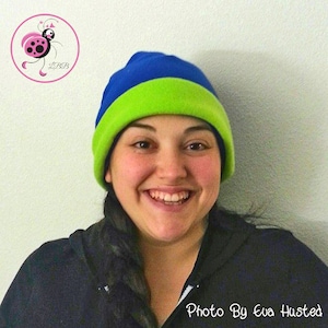 May include: A blue and green fleece beanie hat. The hat has a blue top and a green band. The image also includes a pink and black ladybug logo and the text "Photo By Eva Husted".