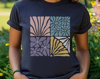 May include: A dark heather grey t-shirt with a square graphic design featuring four different floral patterns in pink, purple, blue, and yellow.