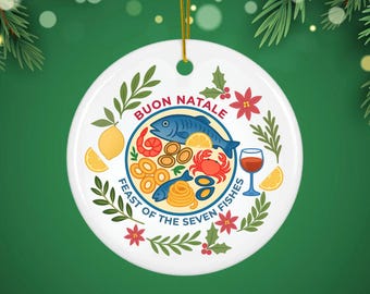 May include: A round white ceramic ornament featuring a colorful illustration of a seafood platter with fish, crab, shrimp, and shellfish. The text reads BUON NATALE and FEAST OF THE SEVEN FISHES, surrounded by lemon slices, wine, and green holly leaves.
