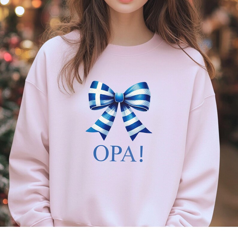May include: Pink sweatshirt with a blue and white bow featuring the Greek flag and the word "OPA!" printed below.