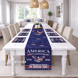 May include: A dining table set with a navy blue table runner and matching placemats. The runner and placemats feature an eagle design with red, white, and blue accents, and text that reads "AMERICA 250th ANNIVERSARY 1776-2026".