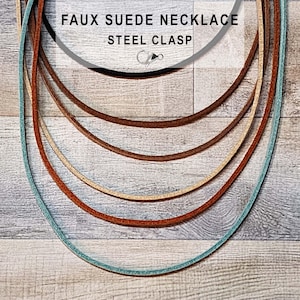 May include: A collection of faux suede necklaces in black, brown, tan, and turquoise, each featuring a silver-toned steel clasp. The text FAUX SUEDE NECKLACE STEEL CLASP is printed at the top, accompanied by a small icon of a lobster claw clasp.