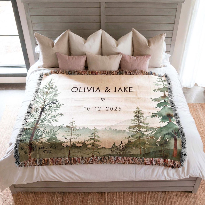 Personalized wedding blanket with names and date, forest design woven cotton throw displayed outdoors near lake