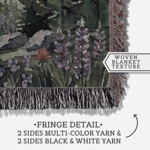 Peut inclure: Une couverture tiss&eacute;e pr&eacute;sentant un paysage vert fonc&eacute; avec des fleurs de lupin violettes et une fleur rouge. La couverture a un tissage textur&eacute; et des d&eacute;tails de franges sur les bords, avec deux c&ocirc;t&eacute;s en fil multicolore et deux c&ocirc;t&eacute;s en fil noir et blanc.