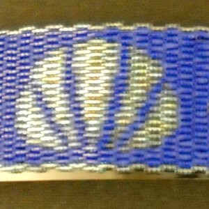 May include: A blue and white beaded bracelet with the word "Peace" woven into the design.