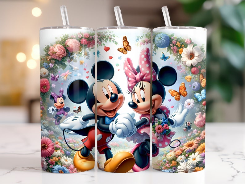 May include: Three stainless steel tumblers featuring a floral design and images of Mickey Mouse and Minnie Mouse. The tumblers are white with a clear lid and a straw.