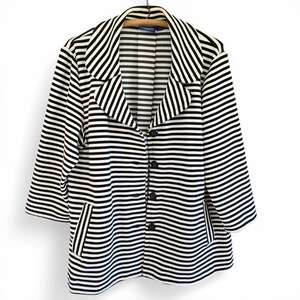 May include: A black and white striped blazer with three-quarter sleeves. The blazer features a notched collar, a three-button closure, and two front pockets. The garment is suspended on a wooden hanger.