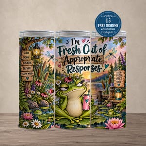 May include: A cylindrical tumbler featuring a green frog wearing a flower crown, holding a pink cup. The design includes a lake scene with cattails, dragonflies, and lanterns. Text reads: I'm Fresh Out of Appropriate Responses, Slow Down, Breathe, Be Silly, Stay Wild, and Good Froge Vibes Only.