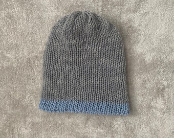 Hand made reversible beanie made with natural merino wool in grey and powder blue. Customise with your favourite colour pom-pom.