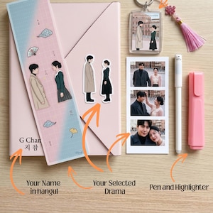 May include: A stationery set featuring a light pink notebook, a bookmark with a couple illustration, two die-cut stickers of the same couple, a clear keychain with a tassel, a photo strip of a couple, a white pen, and a light pink highlighter.