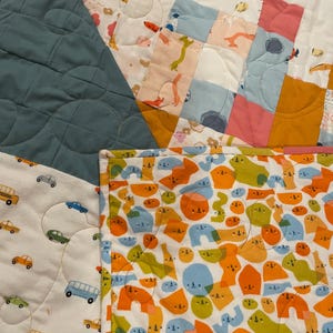 May include: A patchwork quilt with a variety of colorful fabrics. The quilt is made up of squares and rectangles, and features a variety of patterns, including animals, geometric shapes, and abstract designs. The quilt is a great way to add a touch of color and personality to any room.