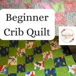 Może przedstawiać: Ręcznie robiona kołdra do łóżeczka z patchworkowym wzorem. Kołdra posiada kwadraty z różowych, zielonych i szarych tkanin w kropki i wzory dinozaurów. Na kołdrze widnieje napis "Beginner Crib Quilt".